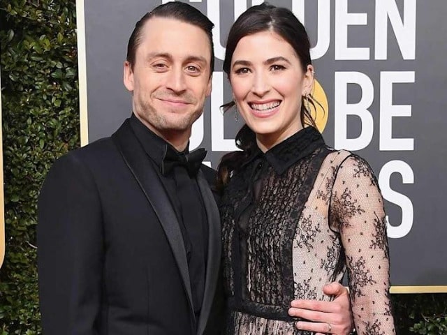 Photo of  Kieran Culkin and his wife wearing a black dress